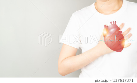 Young female suffering from chest pain and heart organ anatomy with electrocardiogram (ECG) over gray background. Causes of chest pain include palpitation, angina or heart attack. Health care and 137617371