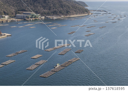 瀬戸内海に広がる牡蠣の養殖筏と沿岸の工業地帯の空撮風景 瀬戸内海に広がる牡蠣の養殖筏と沿岸の工業地帯の空撮風景 137618595