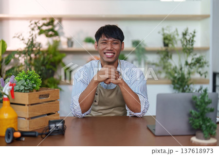 Sustainability: Happy man at a desk surrounded by plants Sustainability: Happy man at a desk surrounded by plants 137618973