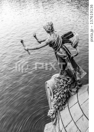 Torch bearer woman figure - bronze decoration of Svatopluk Cech Bridge over Vltava River in Prague, Czech Republic. Black and white image. Torch bearer woman figure - bronze decoration of Svatopluk Cech Bridge over Vltava River in Prague, Czech Republic. Black and white image. 137619136