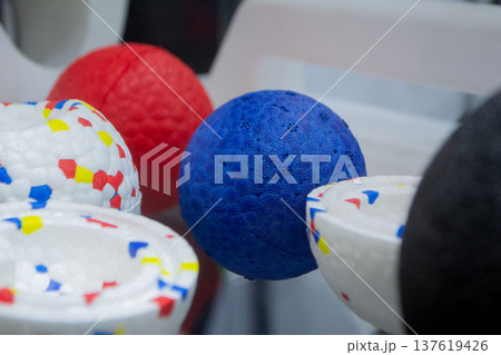 Ball dog toys. Durable foam dog blue red balls close-up. Shape of balls, multi-colored pattern. Object made of material expanded polypropylene EPP, universal foam. New modern industrial technologies. 137619426