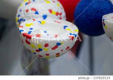 Example object from material expanded polypropylene EPP, universal foam. Durable foam white dog ball toy close-up. Shape of connected balls, multi-colored pattern. New modern industrial technologies. Example object from material expanded polypropylene EPP, universal foam. Durable foam white dog ball toy close-up. Shape of connected balls, multi-colored pattern. New modern industrial technologies. 137620123