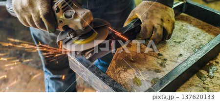 Worker in safety gloves using an angle grinder on metal, creating bright orange sparks, showcasing metalworking, fabrication, and industrial craftsmanship. Worker in safety gloves using an angle grinder on metal, creating bright orange sparks, showcasing metalworking, fabrication, and industrial craftsmanship. 137620133