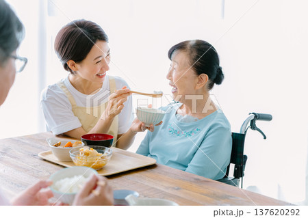 介護士と食事をする老夫婦 137620292