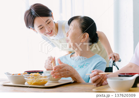 介護士と食事をするシニア女性 介護士と食事をするシニア女性 137620309