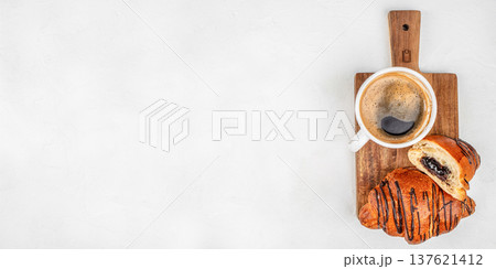 Chocolate croissant with coffee on wooden board top view 137621412