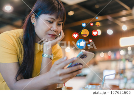 Social media engagement with like and heart icons. Digital marketing and online customer feedback concept. Influencer interacting with followers on smartphone. Woman using smartphone for social media. 137621606