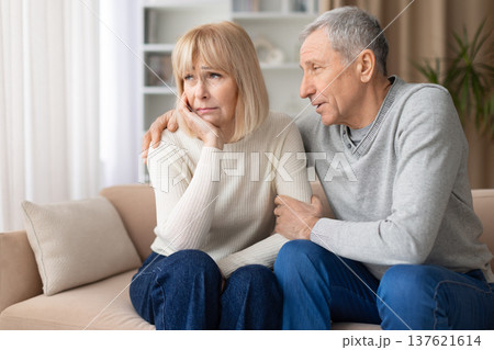 Senior couple sitting on sofa during serious emotional conversation 137621614