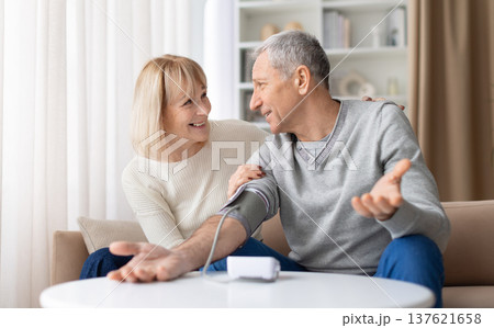 Senior couple measuring blood pressure at home and discussing the results 137621658