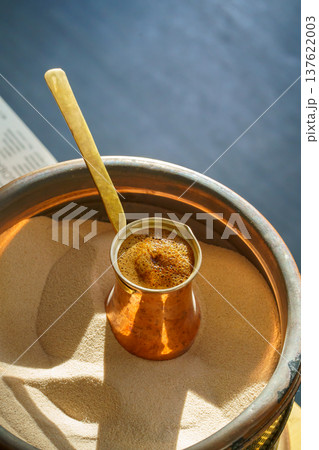 making Turkish coffee in a cezve on the sand, fresh coffee drink making Turkish coffee in a cezve on the sand, fresh coffee drink 137622003