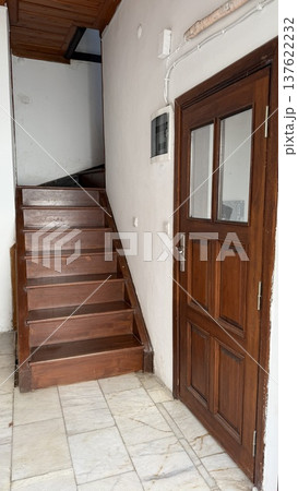 Wooden staircase and door in interior space with natural light and marble floor background 137622232