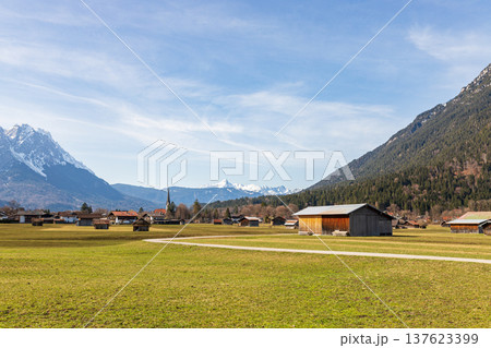 Alpine village with wooden barns and mountain landscape in Garmisch-Partenkirchen, Bavaria, Germany Alpine village with wooden barns and mountain landscape in Garmisch-Partenkirchen, Bavaria, Germany 137623399