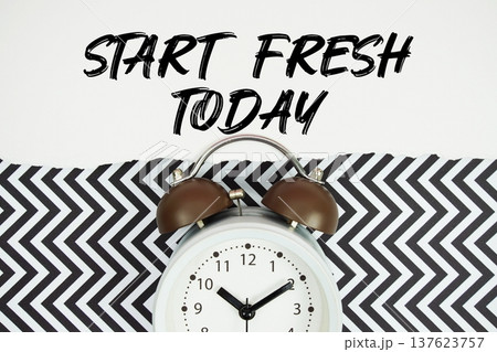 Start Fresh Today text written on paper rip with alarm clock flat lay on black chevron background Start Fresh Today text written on paper rip with alarm clock flat lay on black chevron background 137623757