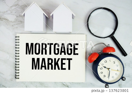 Mortgage Market text written on notepad with house model, magnifying glass and alarm clock on marble background Mortgage Market text written on notepad with house model, magnifying glass and alarm clock on marble background 137623801