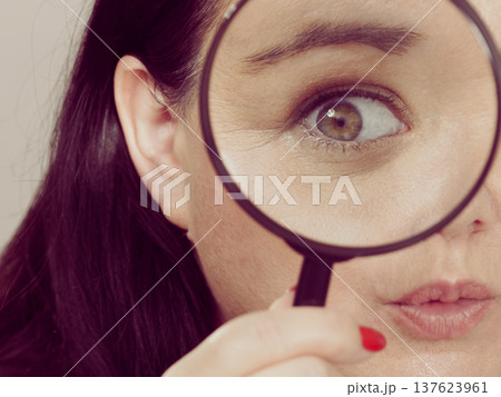 Adult woman with magnifying glss 137623961