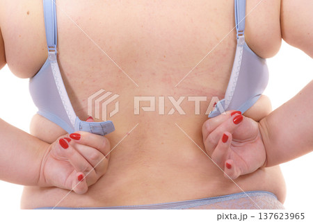 Woman back view putting on her bra lingerie. 137623965