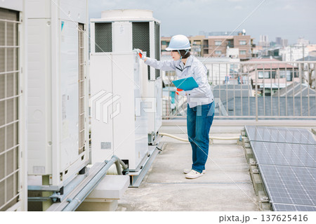 室外機の点検整備を行う女性作業員 室外機の点検整備を行う女性作業員 137625416