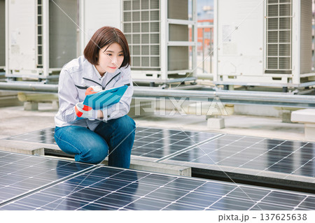 ソーラーパネルの点検をする女性作業員 137625638