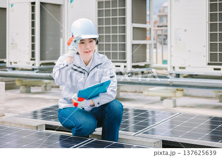 ソーラーパネルの点検をする女性作業員 137625639
