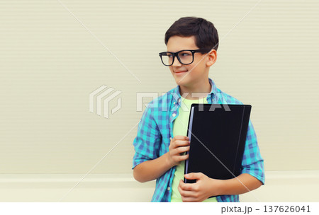happy teenager boy in eyeglasses with folder or book looking away happy teenager boy in eyeglasses with folder or book looking away 137626041
