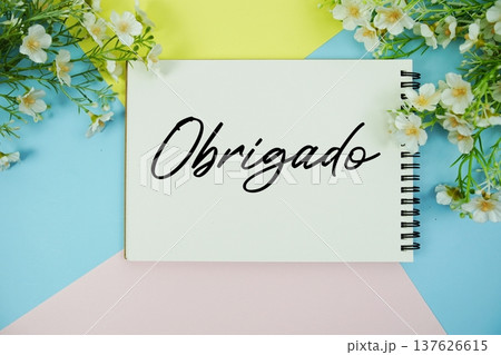 Obrigado text written on notepad with flowers decorations flat lay on multicolor pastel background Obrigado text written on notepad with flowers decorations flat lay on multicolor pastel background 137626615