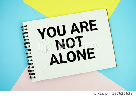 You Are Not Alone text written on notepad flat lay on multicolor pastel background 137626638