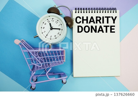 Charity Donate text written on notepad with alarm clock and trolley shopping cart 137626660