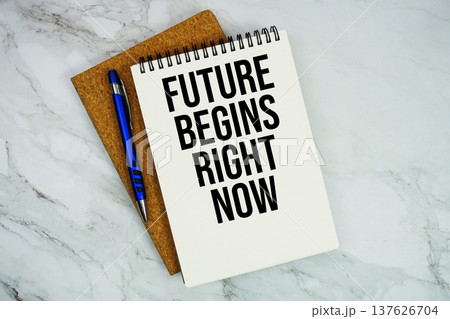 Future Begins Right Now text written on notepad with pen on marble background Future Begins Right Now text written on notepad with pen on marble background 137626704