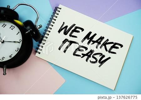 We Make It Easy text written on notepad with alarm clock flat lay on multicolor pastel background We Make It Easy text written on notepad with alarm clock flat lay on multicolor pastel background 137626775