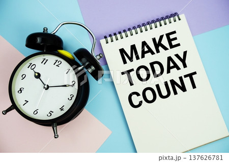 Make Today Count text written on notepad with alarm clock flat lay on multicolor pastel background 137626781