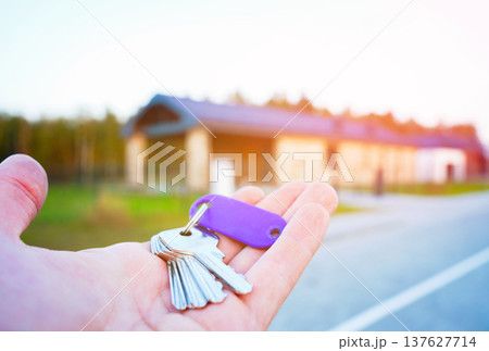 Buying home. Hand holding a bunch of keys at modern private home. Concept of buying real estate Buying home. Hand holding a bunch of keys at modern private home. Concept of buying real estate 137627714