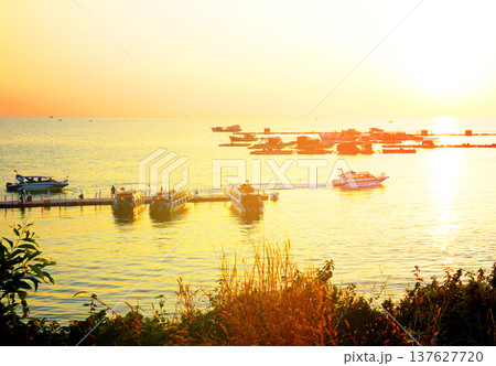 Motorboat in motion at sunset near floating fishermans homes. Speed boat moves on sea water 137627720