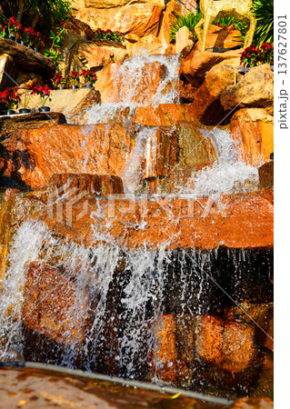 Waterfall close-up background, texture. Water flowing over rocky stones, splashes drops. 137627801