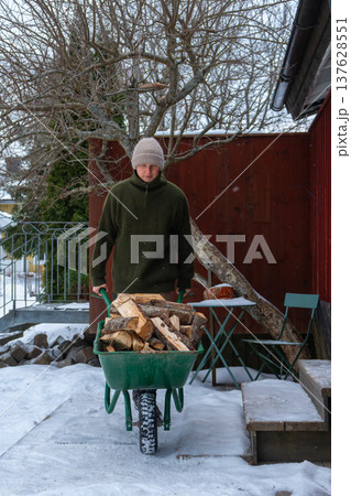 Stacking Firewood Outdoors in Snowy Countryside. Stacking Firewood Outdoors in Snowy Countryside. 137628551