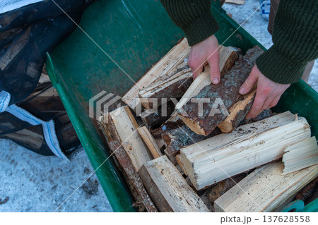 Winter Firewood Preparation by Rustic Wooden Cabin. 137628558