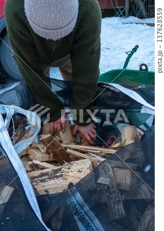 Winter Firewood Preparation by Rustic Wooden Cabin. 137628559