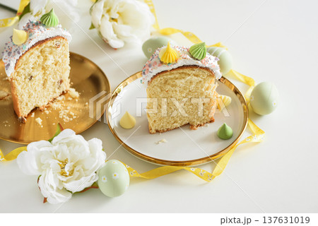 Cutted Easter Cake with Flowers and Pastel Eggs on White Background Cutted Easter Cake with Flowers and Pastel Eggs on White Background 137631019