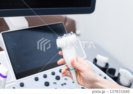 Woman doctor's hand aholding a medical gel to ultrasonic sensor of ultrasound machine in the clinic Woman doctor's hand aholding a medical gel to ultrasonic sensor of ultrasound machine in the clinic 137631080
