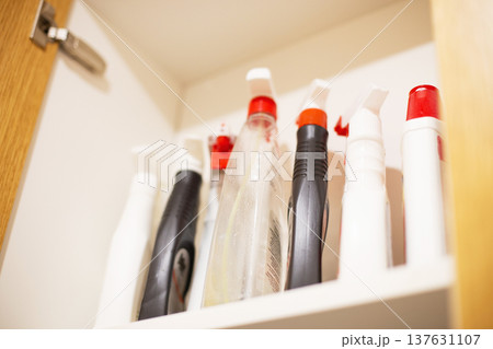 Cleaning spray bottles storing in kitchen cupboard Cleaning spray bottles storing in kitchen cupboard 137631107