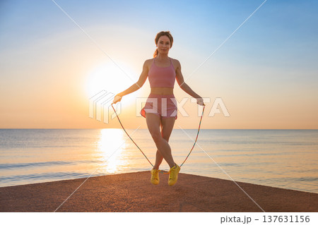 Fit woman jumping rope at the beach during summer vacation 137631156