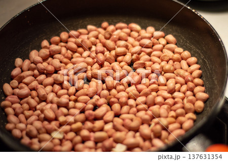 Raw peanuts roasting in frying pan close-up Raw peanuts roasting in frying pan close-up 137631354