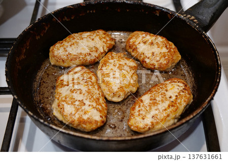 Meat cutlets are fried in a frying pan 137631661