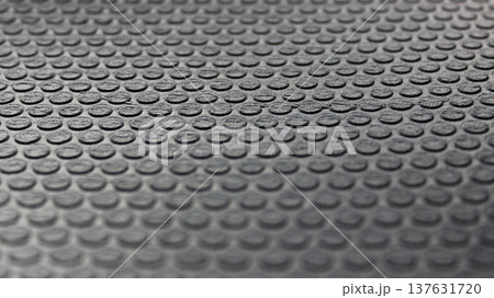 Round elements on a rubberized insulation sheet with blurred top and bottom edges. Rubber texture stock photo 137631720