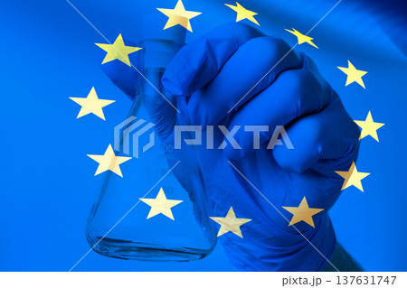 A scientist in the lab works with test tubes, the image of the EU flag, research, biotechnology, pharmaceuticals, healthcare, and innovation. A scientist in the lab works with test tubes, the image of the EU flag, research, biotechnology, pharmaceuticals, healthcare, and innovation. 137631747