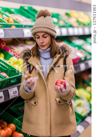 Woman with eating disorder choosing healthy food in supermarket 137631963