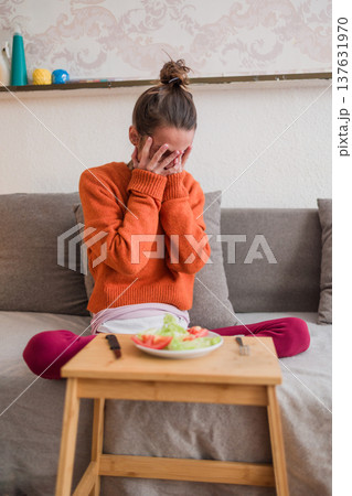 Woman grappling with eating disorder facing small food portion 137631970