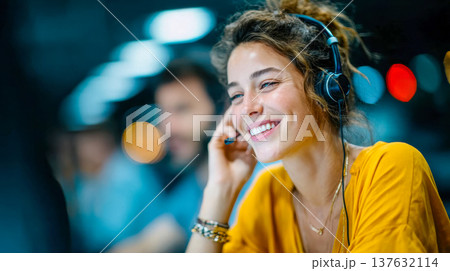 Smiling customer support agent wearing headset in a modern office with soft colorful bokeh lights 137632114