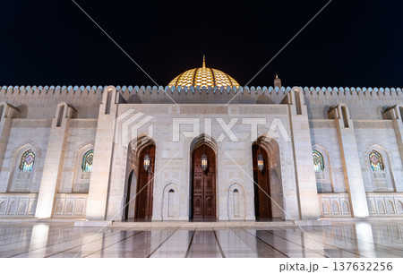 Night view of the Sultan Qaboos Grand Mosque in Muscat, Oman, featuring the illuminated dome and decorative archways of the main entrance. Night view of the Sultan Qaboos Grand Mosque in Muscat, Oman, featuring the illuminated dome and decorative archways of the main entrance. 137632256