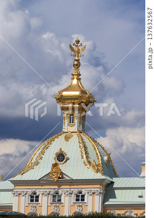 Russia, St. Petersburg, Peterhof, July 8, 2019. In the photo - the main court temple with a double-headed eagle on the dome in the Upper Park of the State Museum Reserve "Petergof" and people who walk Russia, St. Petersburg, Peterhof, July 8, 2019. In the photo - the main court temple with a double-headed eagle on the dome in the Upper Park of the State Museum Reserve "Petergof" and people who walk 137632567