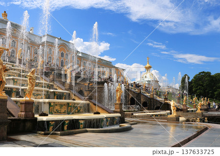 Russia, St. Petersburg, Peterhof, July 4, 2018. On the photo is the Grand Cascade fountain in the Upper Park of the Peterhof State Museum and people who walk in the park Russia, St. Petersburg, Peterhof, July 4, 2018. On the photo is the Grand Cascade fountain in the Upper Park of the Peterhof State Museum and people who walk in the park 137633725